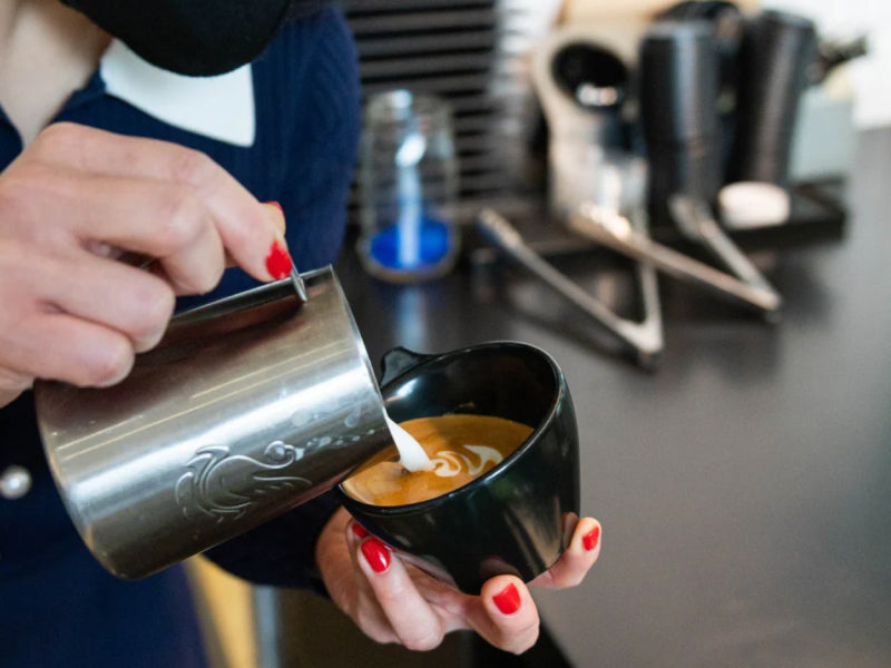 A woman pouring coffee into a mug