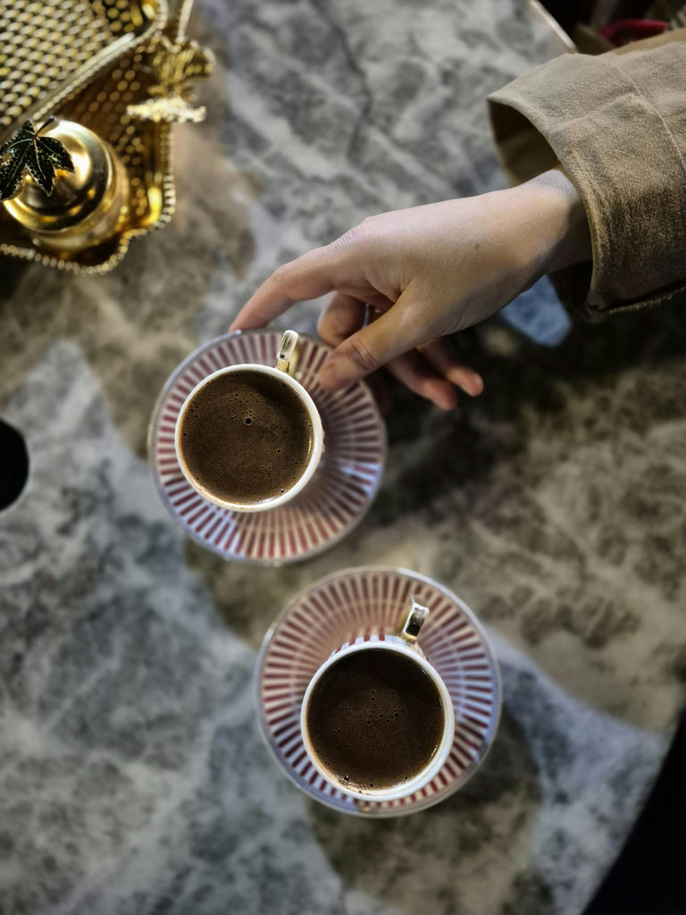 A hand reaches for a cup of coffee